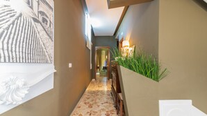 A hallway with a patterned floor, a wall-mounted plant, and a framed artwork. - Holiday Home 'Casa Neathon' with Wi-Fi, Terrace & Balcony (Noto)