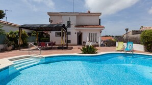 A swimming pool with a covered area, outdoor seating, and a building in the background. - Holiday Home 'Villa Lilia' with Sea View, Private Pool and Wi-Fi (Vilanova i la Geltrú)