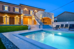 A two-story house with a swimming pool, stone facade, and outdoor seating area. - Luxury Villa Grande (Svetvincenat)
