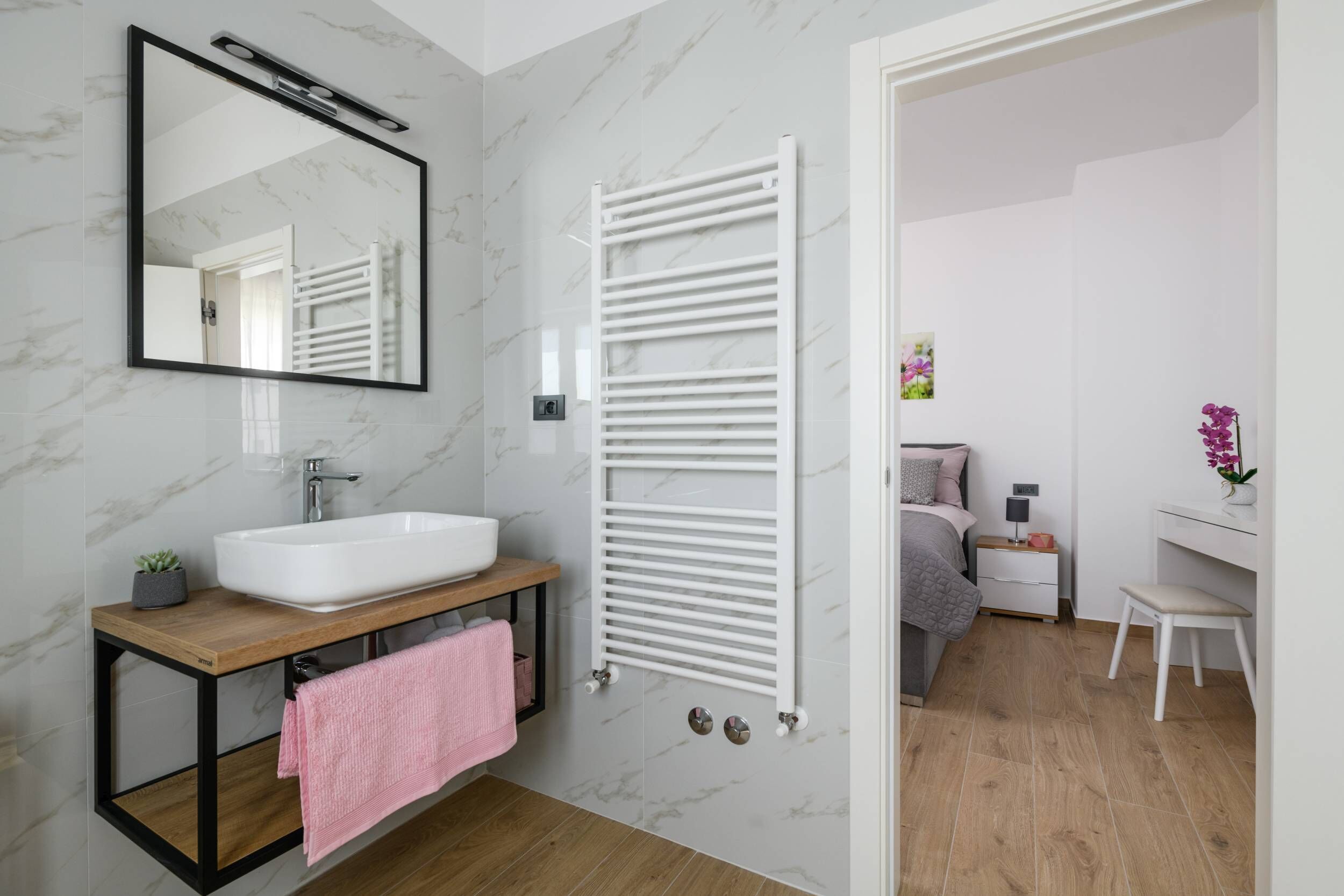 Ein modernes Badezimmer mit Waschbecken, Spiegel und Handtuchhalter.