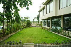 A modern building with large windows and a well-maintained lawn.