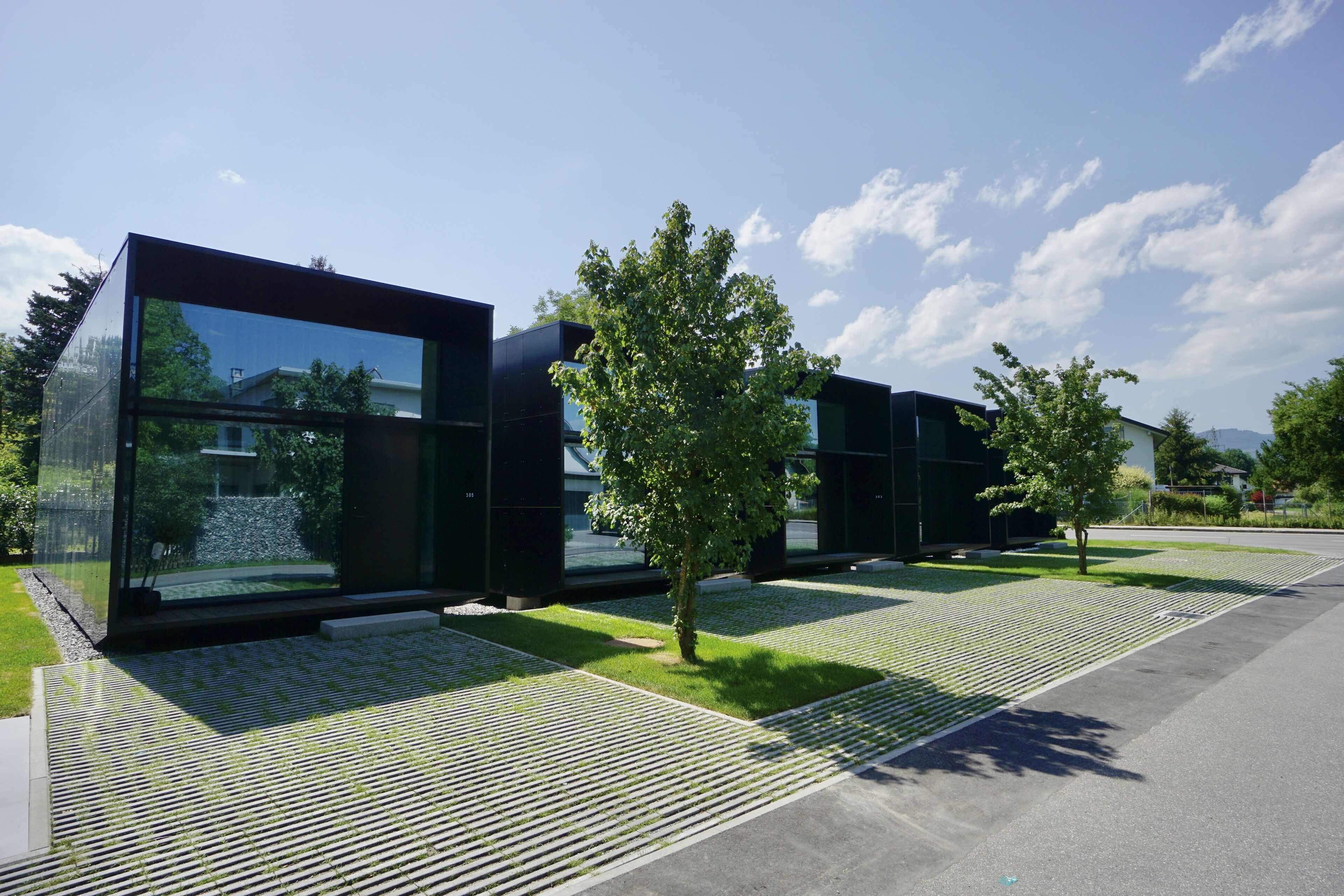 Um edifício moderno com grandes janelas de vidro e um caminho pavimentado.