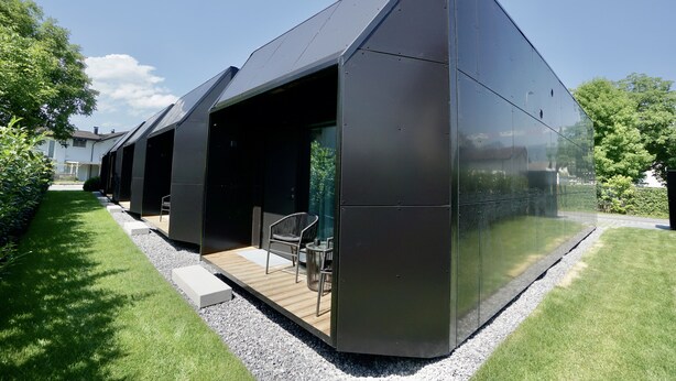 A modern building with a sloped roof and a large glass facade. - Chalet Park by Maier Mäder (Mäder)