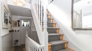 Eine Treppe mit weißen Balustraden und grauen Teppichstufen.
