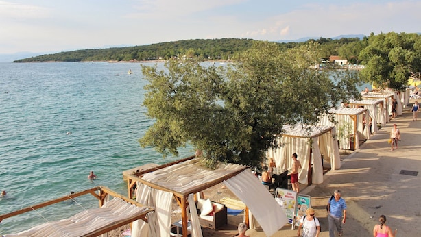 A beachside area with wooden structures, some with canopies, overlooking a calm sea. - Holiday apartment 10 m from the beach (Malinska)