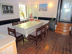 A dining area with a table, chairs, a small refrigerator, and artwork on the walls. - Holiday apartment 10 m from the beach (Malinska)