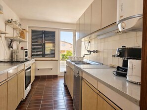 Eine moderne Küche mit Einbauofen, Kaffeemaschine und Spüle.