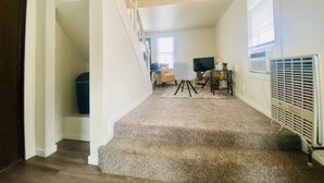 A staircase leading to a living area with a TV, a desk, and a chair. - The Tiny Piney Loft - Live. Work. Play. Downtown Green Bay! (Green Bay)