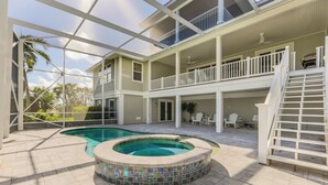 A two-story house with a swimming pool and a covered patio area.