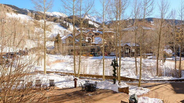 A snow-covered outdoor area with a brick patio, benches, and a table. - Ultimate Location by InvitedHome | Hike, Bike, Shops, Restaurants, Gondola (Mountain Village)