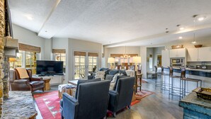 A spacious living room with a stone fireplace, a large flat-screen TV, and a comfortable seating area. - Ultimate Location by InvitedHome | Hike, Bike, Shops, Restaurants, Gondola (Mountain Village)