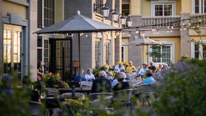 Un espace extérieur aménagé avec des tables et des chaises, entouré d’immeubles dotés de balcons et de fenêtres.