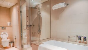 Une salle de bain moderne avec une douche à parois de verre, une baignoire blanche et des toilettes.
