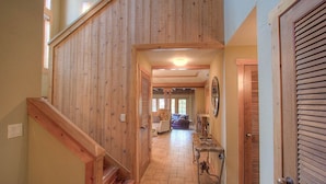 A wooden staircase leading to a living area with a sofa and a table.