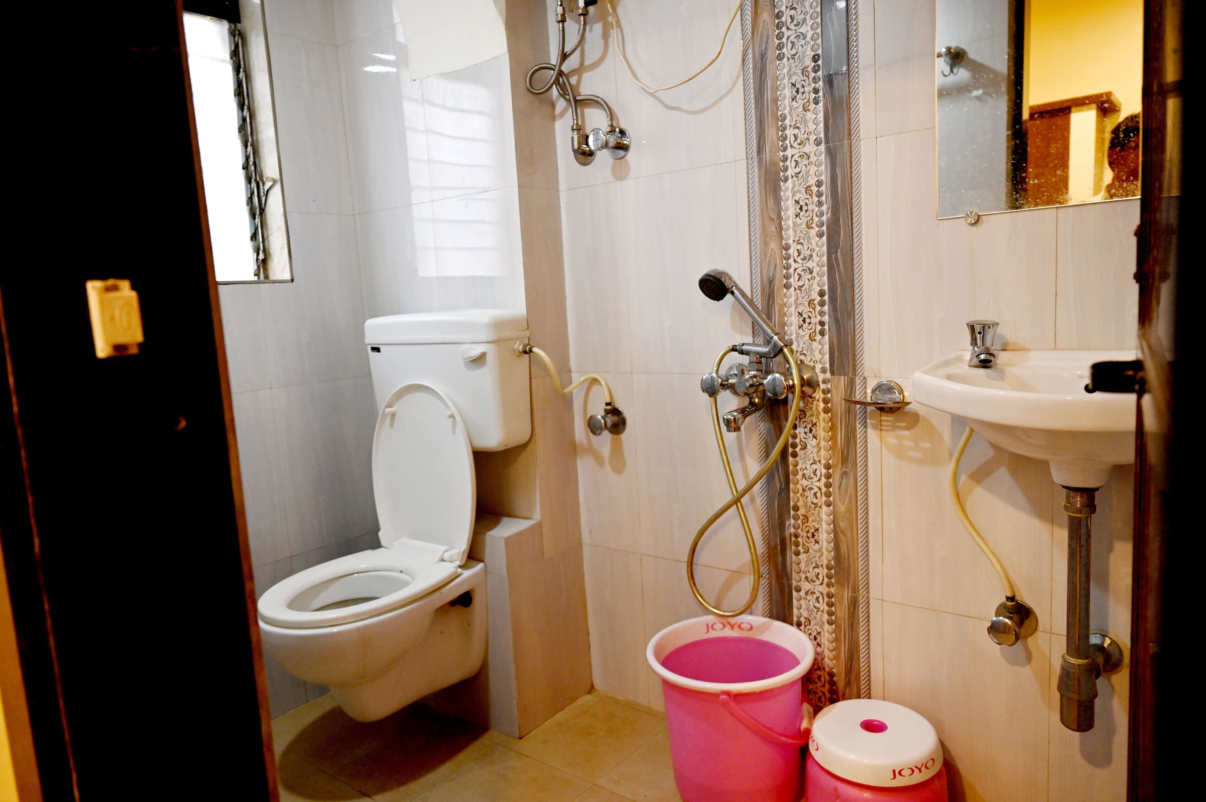 A bathroom with a toilet, shower, and sink.