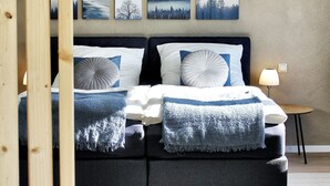 A bedroom with a bed, bedside tables, and artwork on the wall.