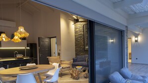 A modern living space with a dining area, a sofa set, and a glass coffee table. - High-end Villa Lyra close to Desimi beach with heated pool (Lefkada)