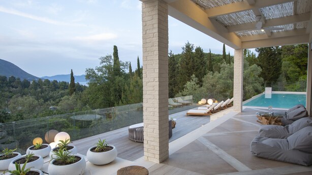 A modern outdoor lounge area with a pool, potted plants, and seating. - High-end Villa Lyra close to Desimi beach with heated pool (Lefkada)