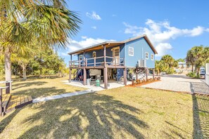 A two-story house with a covered porch and a garage. - Coastal Getaway on canal-steps to the beach (Panacea)