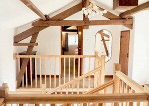 Eine Holztreppe mit Geländer, die zu einer oberen Etage führt.