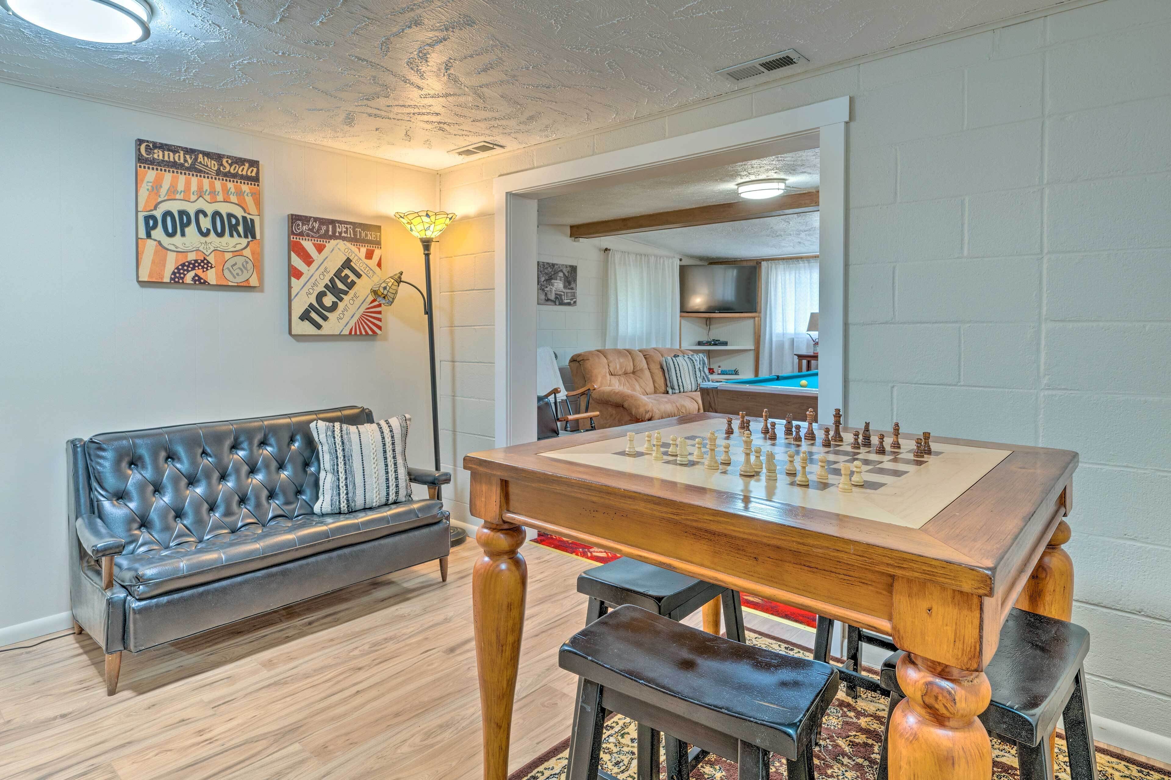Un salon comprenant une table d’échecs, un canapé et deux éléments de décoration murale.