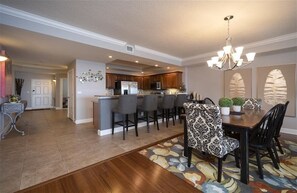 A spacious kitchen with a central island, bar seating, and a dining area with patterned chairs.