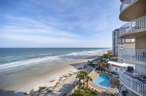 Un hôtel en bord de mer doté d’une piscine, offrant une vue sur l’océan et comprenant plusieurs balcons.