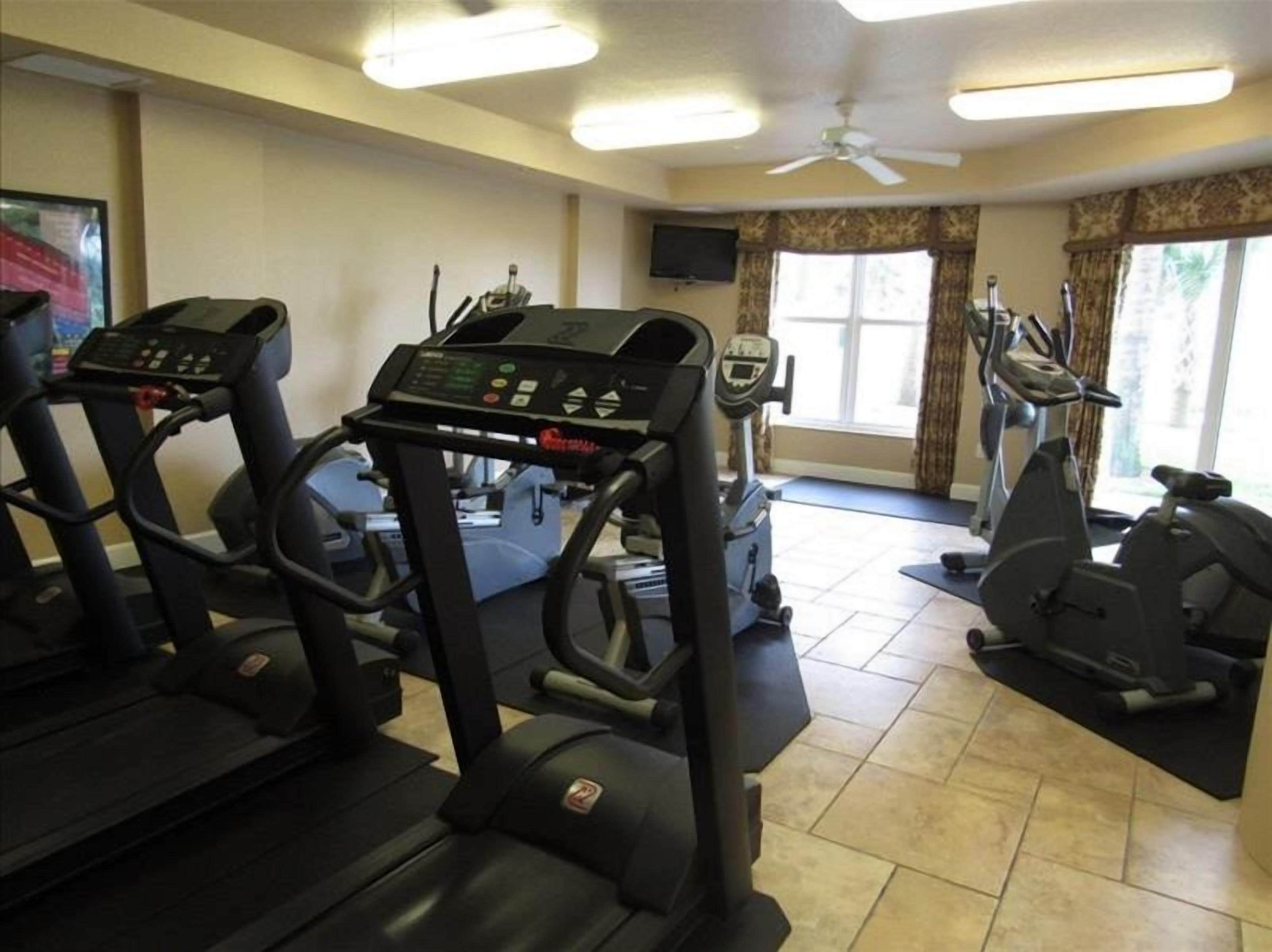 A gym with treadmills, elliptical machines, and stationary bikes.