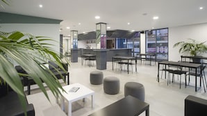 Un espace de détente moderne, doté de différents types de sièges, d’un comptoir d’accueil et d’une enseigne bien visible portant le mot « BOD ».