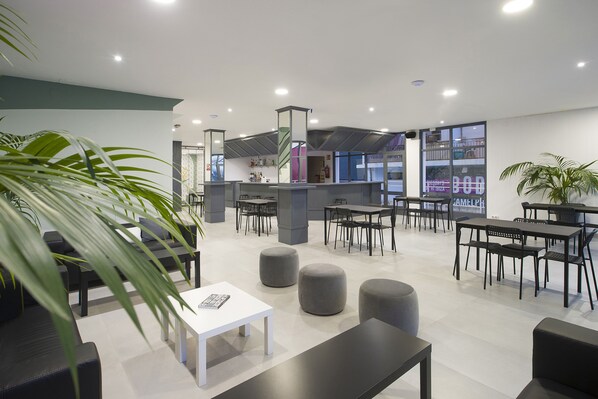 A modern lounge area with seating arrangements, a reception desk, and a visible sign with the word "BOD". - Hotel Base Ibiza (Sant Antoni de Portmany)