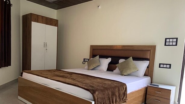 Un dormitorio con una cama grande, cabecera de madera, dos mesitas de noche y un armario.