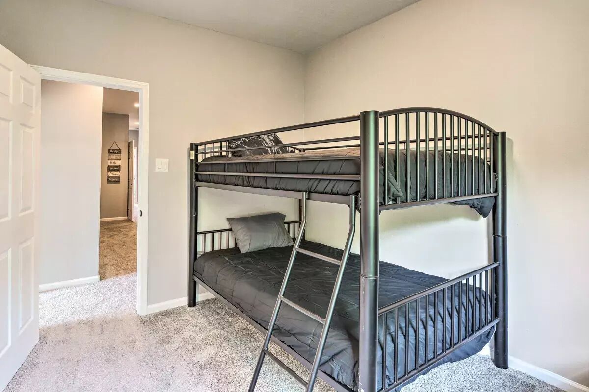 A bunk bed with a ladder, a door leading to another room, and a wall with a sign.