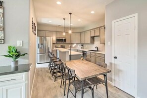A modern kitchen with a central island, stainless steel appliances, and pendant lighting.