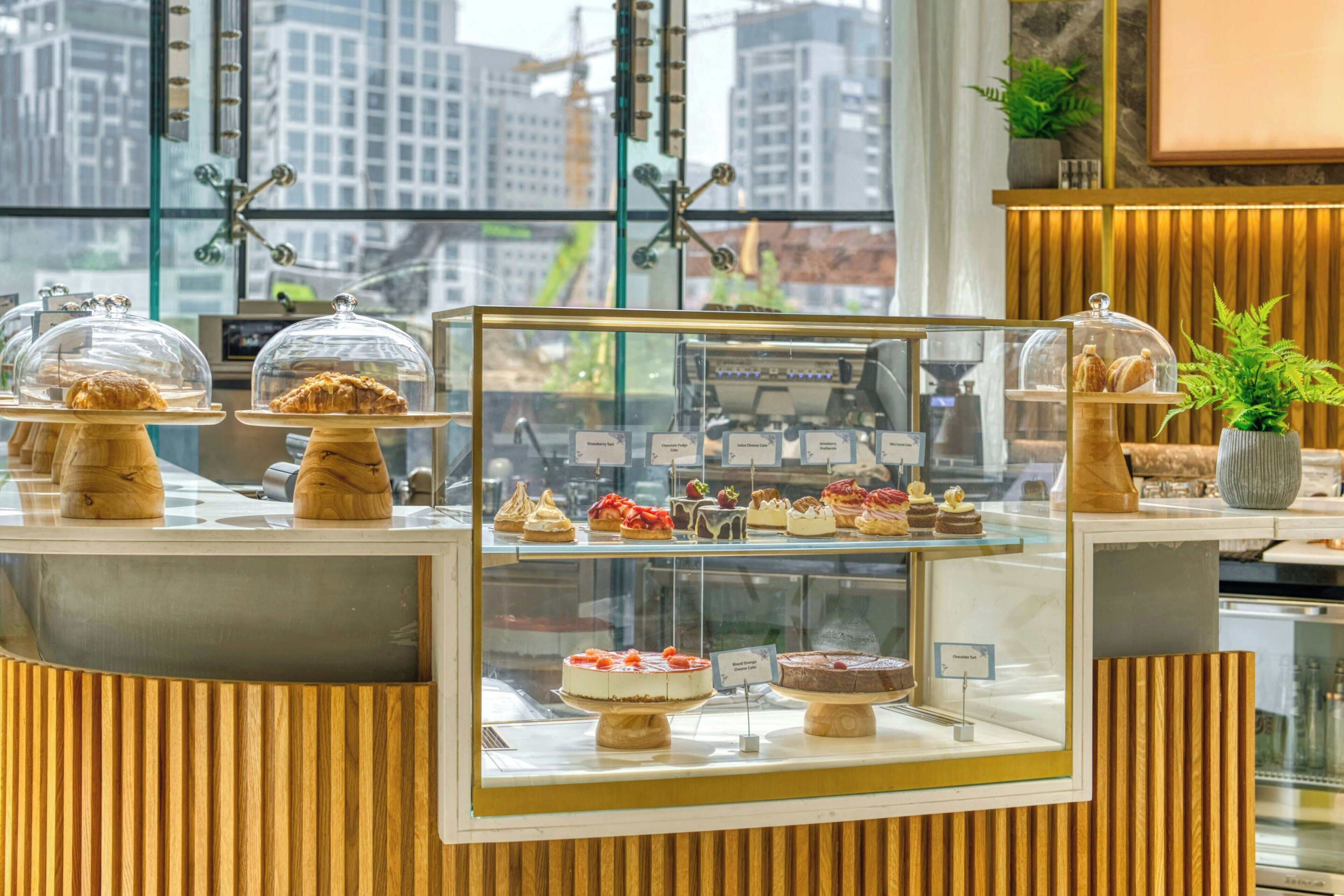 A dessert display case in a cafe with various pastries and cakes.