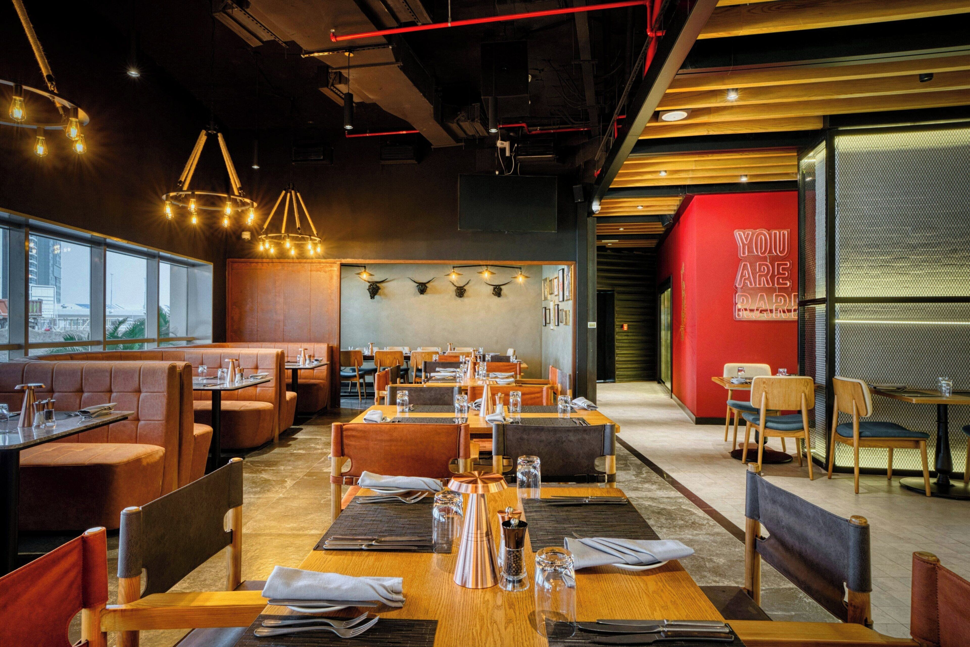 A restaurant interior with booths, tables, and a red accent wall.