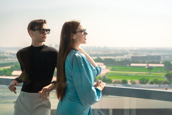 Two people standing by a window overlooking a cityscape. - The First Collection Business Bay, Dubai, a Tribute Portfolio Hotel (Dubai)