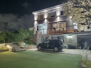 A modern two-story house with a car parked in the driveway.