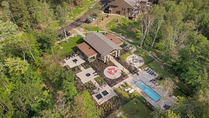 Vista aérea de una propiedad residencial con una casa grande, piscina y un jardín bien cuidado.