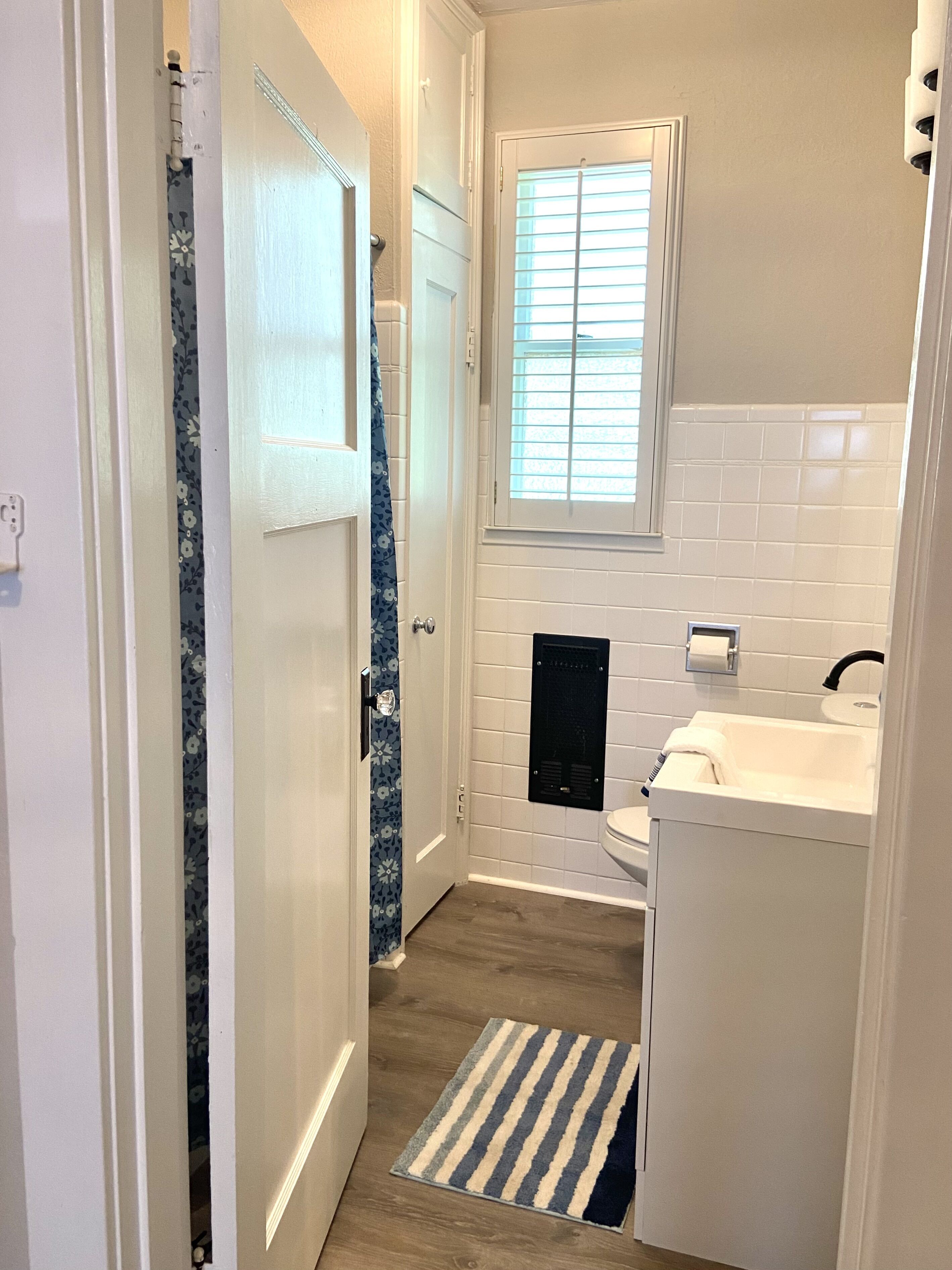 A compact bathroom with a toilet, sink, and window.