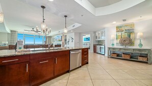 A spacious kitchen with a large island, stainless steel appliances, and a modern chandelier. - Turquoise Place!  New Rental!! (Orange Beach)