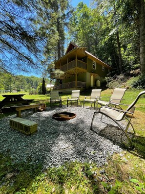 A lodge with a porch, outdoor seating, and a fire pit. - CABIN MINS TO SNOWSHOE-RESORT,BIKING,HIKING,MOTORCYCLE RIDING (Dunmore)