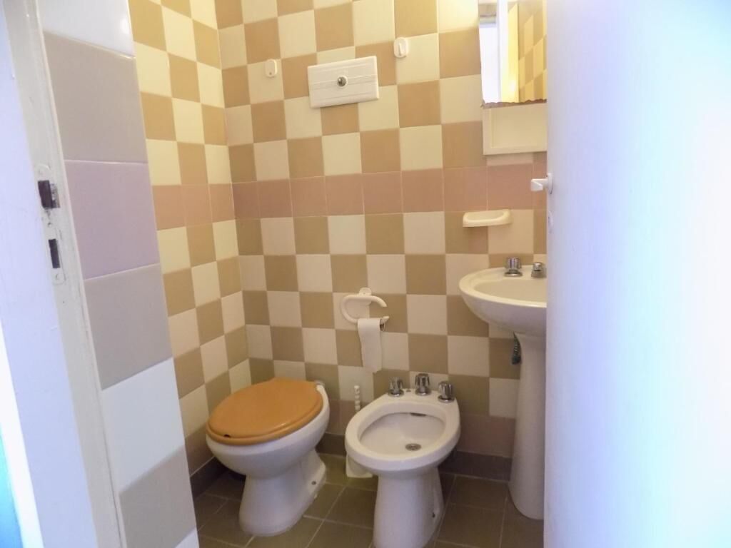 Un baño con inodoro, bidé y lavamanos.