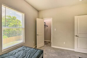 A bedroom with a single bed, a window with blinds, and a closet with a hanging rack. - NEW! Welcoming Texas City Home ~ 6 Mi to Beach! (Texas City)