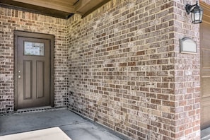 A brick exterior with a brown door and a small window. - NEW! Welcoming Texas City Home ~ 6 Mi to Beach! (Texas City)