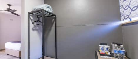 A compact hotel room with a bunk bed, a small desk with toiletries, and a ceiling fan.