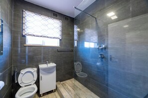 A modern bathroom with a shower, toilet, and sink.