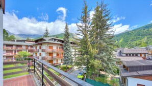 Un quartier résidentiel avec des immeubles à plusieurs étages, des balcons et une vue sur une montagne.