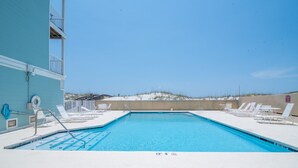 Una piscina con vista diretta sulla spiaggia e sulle dune sullo sfondo.