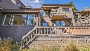 A multi-story house with a wooden exterior, large windows, and a balcony. - Snowflake Lookout: Ski In/Out Breckenridge Townhome with Hot Tub (Breckenridge)