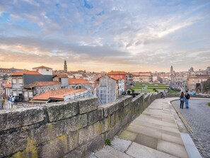 A stone bridge with steps leading to a cityscape.
